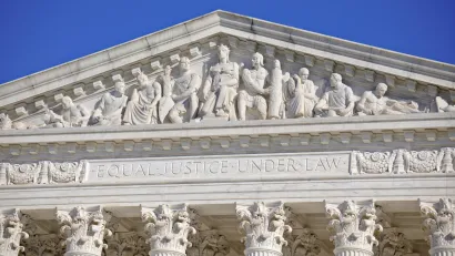 Close-up of U.S. Supreme Court building with "Equial Justice Under the Law" carving across top.